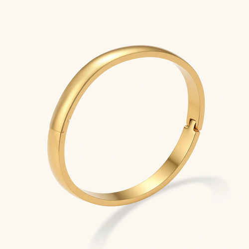 Polished 18K gold plated stainless steel hinge bangle with smooth flat-top profile on cream background.